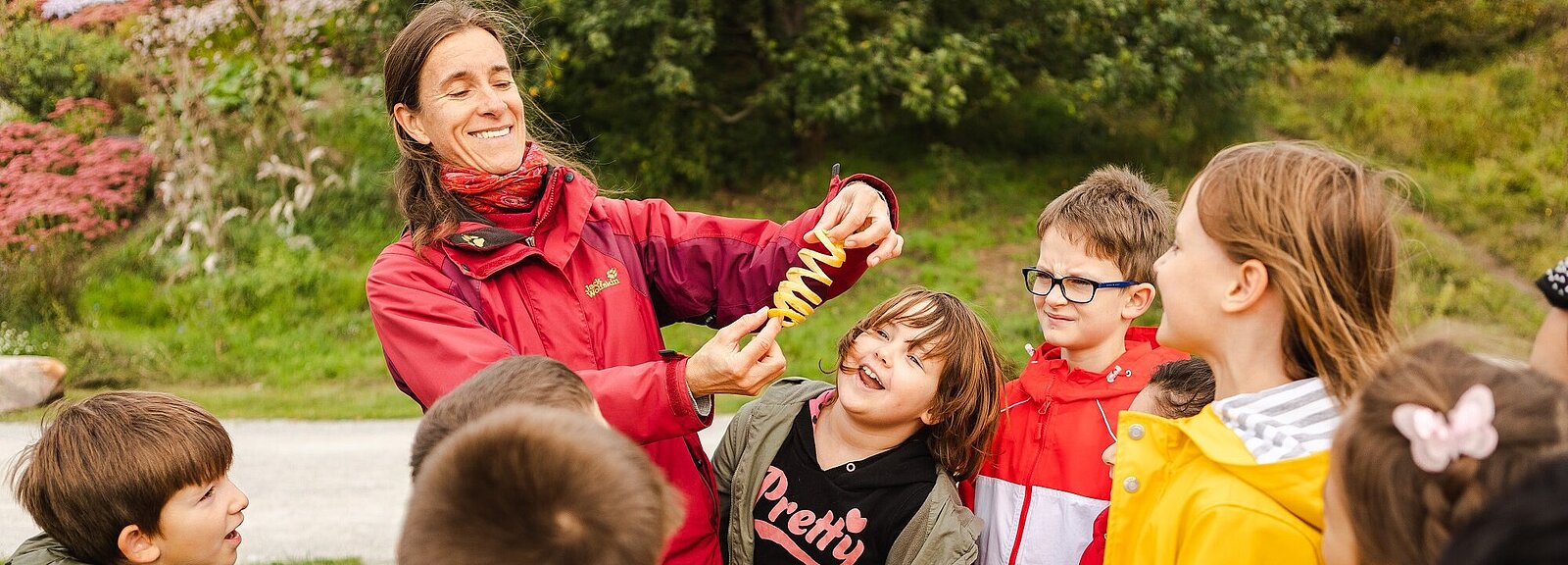 Eine Frau zeigt Kindern eine Apfelschalenspirale
